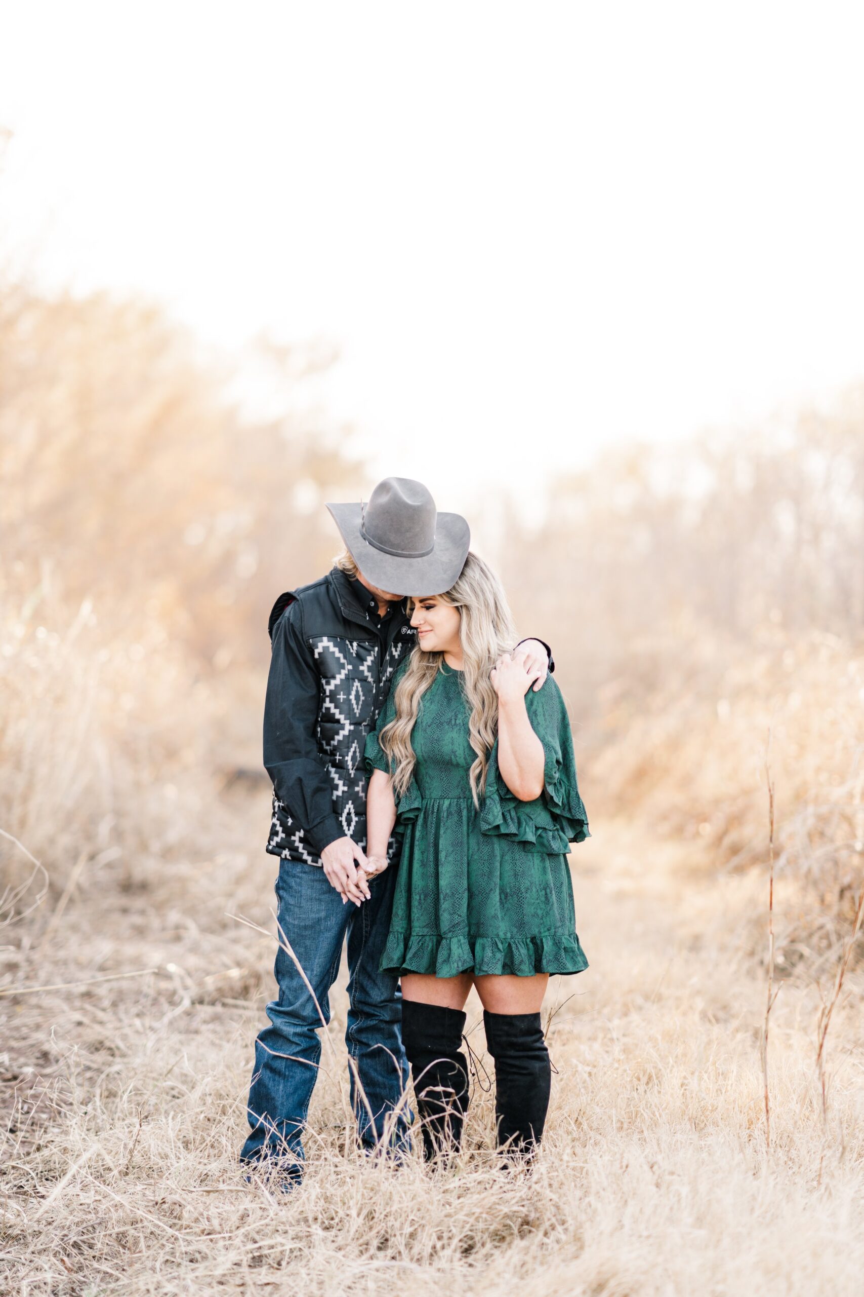 Texas wedding photographer works with newly engaged couple to create beautiful image in a field