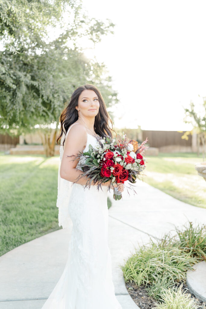 photo of bride holding a bouquet of red roses