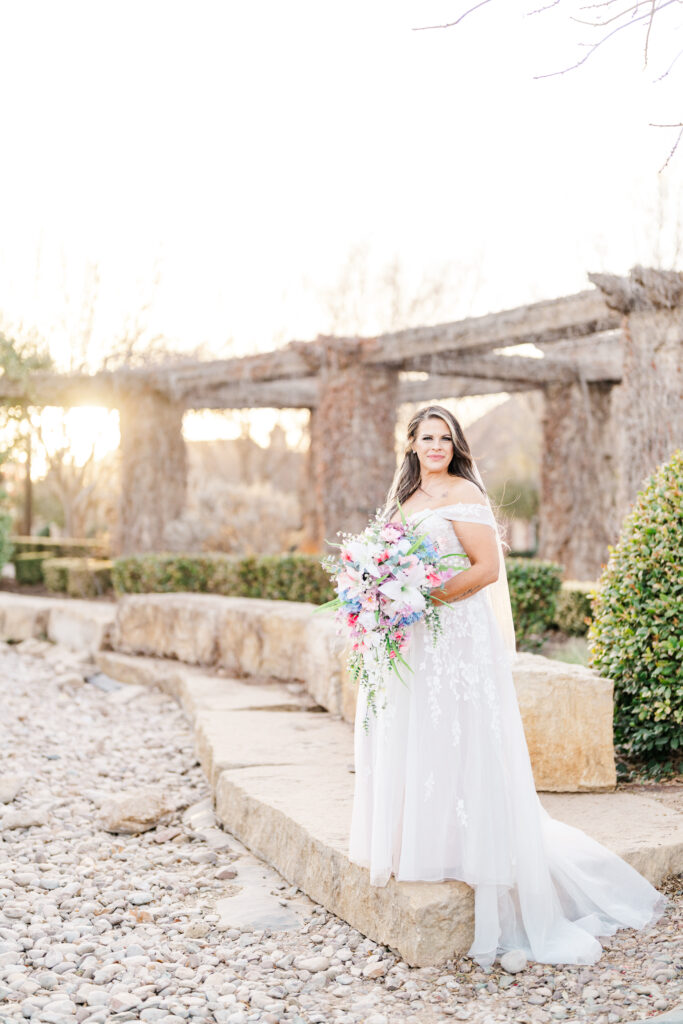 Bridals photos with bride standing in a park with a cascading colorful bouquet. 