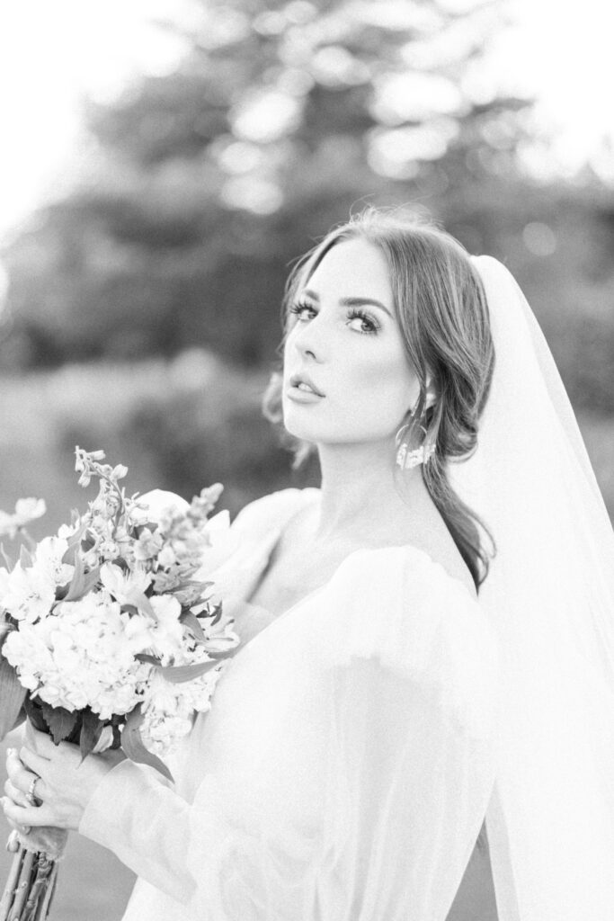wedding photographer in dallas captures a photo of a bride holding a simple and natrual bouquet with a long sleeve wedding dress